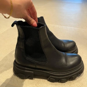 Svarta chelsea boots - Snygga svarta chelsea boots med grov sula. Sparsamt använda och i väldigt fint skick! Kan skickas eller mötas upp i göteborg. Storlek 37 men passar mig som normalt har 38! 