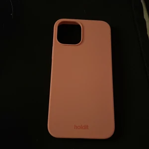 Rosa mobilskal från Holdit - Snyggt och stilrent rosa mobilskal från Holdit. Skalet har en slät yta och är designat för att skydda din telefon samtidigt som det ger ett modernt utseende. Passar iPhone 12 PRO. ALDRIG ANVÄNT 