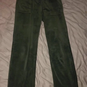 Gröna mjukisbyxor från Juicy Couture - Snygga gröna mjukisbyxor från Juicy Couture i storlek S. I fint skick och sitter jätte bra på. Älskar dessa och är köpta för 1299kr men säljer för 350kr. Skriv för fler bilder eller frågor☺️finns ett litet märke på knät men inget som syns mycket. Kan skicka bild 