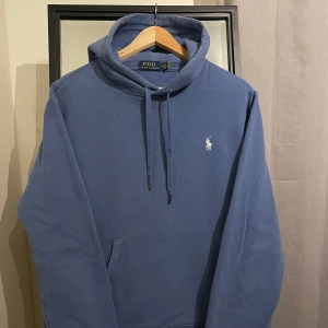Ljusblå hoodie från Polo Ralph Lauren - Säljer en snygg ljusblå hoodie från Polo Ralph Lauren, storlek M (passar även S) funkar även som unisex. Nypris 2400kr säljes nu för enbart 1099kr Den har en klassisk design med en liten vit logga på bröstet och justerbar dragsko i huvan. Perfekt för en avslappnad stil och passar till de flesta tillfällen. Skön och bekväm att ha på sig!