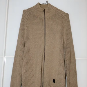 Beige stickad kofta från Mexx - Säljer en snygg beige stickad kofta från Mexx i storlek XL. Den har en dragkedja framtill och en hög krage som håller dig varm under kyliga dagar. Perfekt för höst och vinter! 🧥