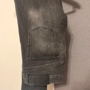 Grå jeans från J.Lindeberg - Säljer ett par feta grå jeans från J.Lindeberg i bra skick. Dem är en sällsynt model och Passar till allt och ger en stilren look. Strl 32/32