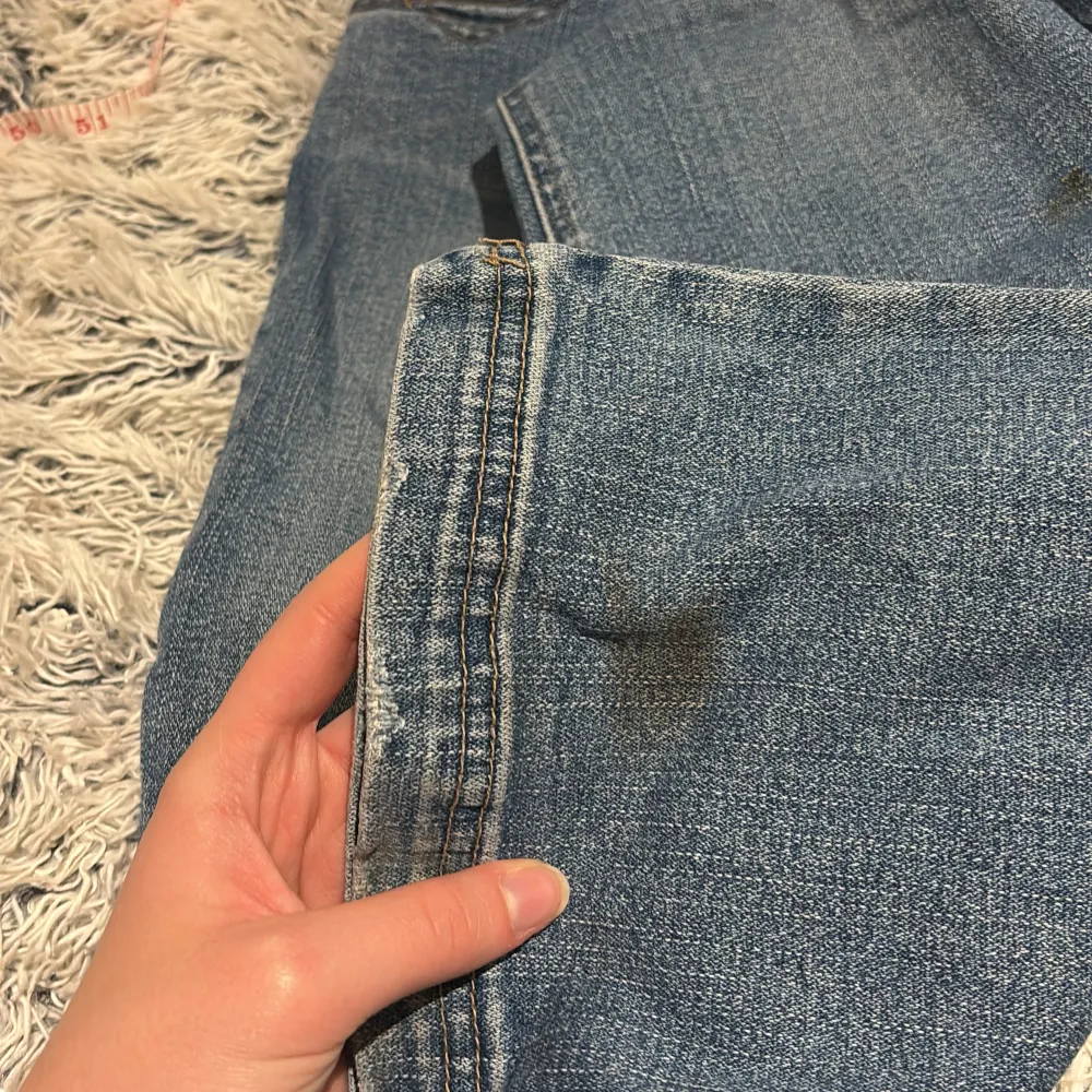 Säljer ett par snygga blå bootcut jeans i bra skick. De är lågmidjade och har en söt hjärtdetalj på bakfickorna. Perfekta för både vardag och fest! 💙jag är 173cm lång 🥰 finns en liten fläck längst ner på baksidan av vänstra benet som säkert är lätt att få bort i tvätten . Farkut & Housut.