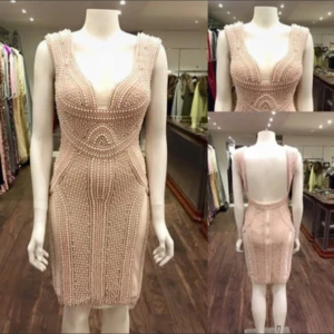 Beige pärlbroderad klänning - Säljer en superfin beige klänning med pärlbroderi. Den har en tight passform och är ärmlös med en öppen rygg. Perfekt för fest eller nyår! Klänningen är i mycket bra skick och ger en lyxig känsla med sina detaljer.