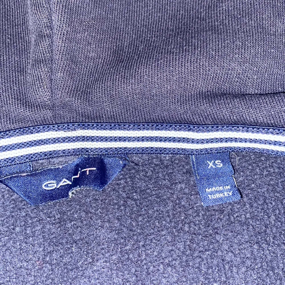 Säljer en snygg mörkblå hoodie från GANT i storlek XS. Den har en dragkedja framtill och stora bokstäver på bröstet. Perfekt för höst och vinter, och den är superbekväm med sin mjuka insida. Passar både till vardags och chillkvällar. Ny pris runt 1000 kr men mitt pris är endast 299 !!. Tröjor & Koftor.