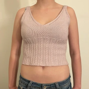 Beige stickad linnetopp - Säljer en superfin ljuslila hemmagjord stickad linnetopp i croppad modell. Den har en v-ringad hals och breda axelband, perfekt för sommardagar. Toppen är i mycket bra skick och passar perfekt till jeans eller kjol. Perfekt för en avslappnad men stilren look!