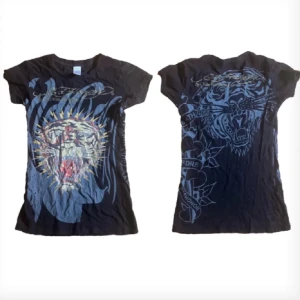 edhardy t-shirt  - Jätte fin edhardy tröja köpt p Plick, säljer för att de är inte min stil längre. Storlek S. Vissa rinestones har lossnat (bild 2) men man märker knappt de.