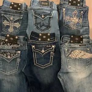 Söker ett par jeans från Miss Me med snygga broderade detaljer på bakfickorna. De har olika mönster som kors och vingar, och är dekorerade med pärlor och knappar. Och de ska vara storlek S,170 eller 32/34