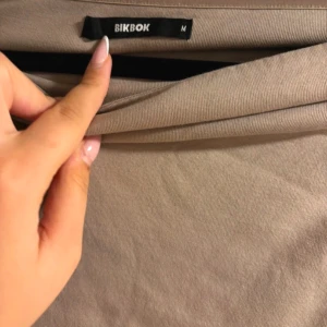 Beige offshoulder topp från BikBok - Säljer en snygg beige offshoulder topp från BikBok i storlek M. Perfekt för sommardagar eller en kväll ute. Toppen är i ett mjukt och bekvämt material som sitter skönt mot huden.