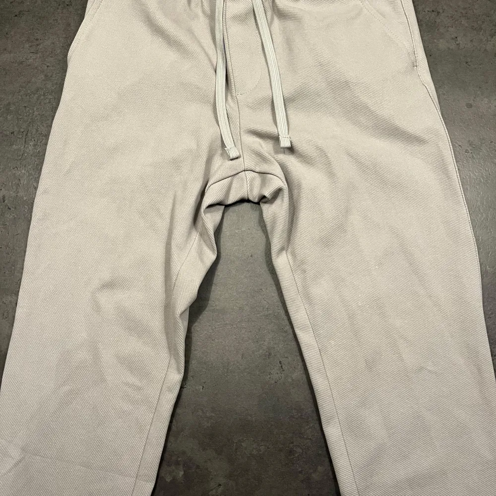 Säljer ett par bekväma beige/grå stiliga joggerbyxor från ZARA i bra skick. De har en avslappnad passform med snörning i midjan för justerbar komfort. Perfekta för en chill dag hemma eller vardaglig tillställning. Passar till alla säsonger och är ett måste i garderoben! Nypris 500:-. Farkut & Housut.