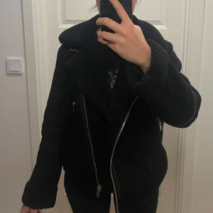 Kort Svart jacka  - svart kort jacka. Den har en dragkedja framtill och är perfekt för höst och vinter. 