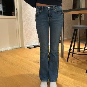 Blå bootcut jeans - Säljer ett par snygga blå bootcut jeans i mycket bra skick. Grunt Texas Low flare. De är medelmidjade och har en klassisk femficksdesign med knappar och dragkedja fram. Perfekta för både vardag och fest! 🦋 ett litet lagat hål på höger bakben 