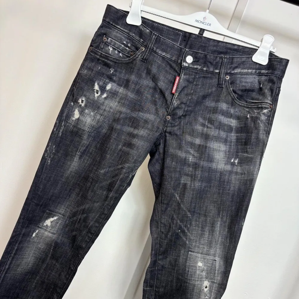 Säljer ett par coola svarta jeans från Dsquared2 i bra skick. De har en distressed look med slitningar och en snygg tvätt. Perfekta för en avslappnad stil med en touch av edge. Passar både till vardags och fest!. Jeans & Byxor.