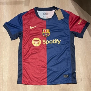 FC Barcelona fotbollströja - Säljer en replika av Barcelonas hemmatröja 24/25, storlek S. Tröjan är i perfekt skick, aldrig använd och har alla originaltaggar kvar. 