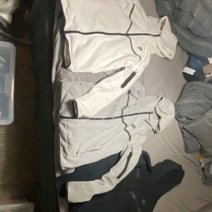 Nike huvtröjor i olika färger  - Säljer tre snygga Nike huvtröjor i svart, grått och vitt. Alla har dragkedja och huva, med en cool ficka på ärmen. Perfekta för höst och vår, och de är i mycket bra skick. Passar både för träning och vardag. Ingen av dom har håll eller slitningar och en för 500 kr och om man vill ha alla tre så blir det 1300 kr alltså 200 kr Rabbat. Vita är M, svarta är M, gråa är S.