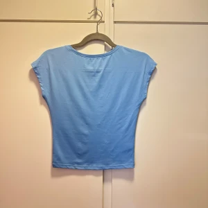 Ljusblå topp med öppen rygg - Säljer min ljusblåa topp med öppen rygg från bikbok då jag inte använder den, den har knapp heller blivit använd och därmed inga tecken på användning. Materialet är jätteskönt och lent. Den är normal i storleken 