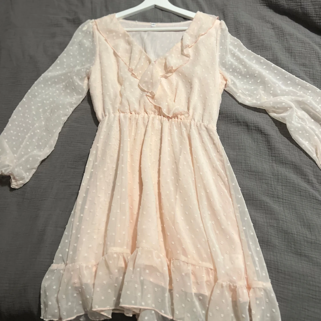 Ljusrosa klänning med volangdetaljer