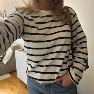 Randig långärmad tröja från Zara - Långärmad randig tröja i vitt och marinblått från Zara med knappdetaljer på ärmarna. Storlek M, jag på bilden har normalt S-M/38. Bra skick! 💙