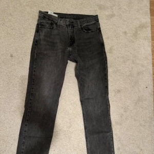 Svarta jeans från Levi's - Säljer ett par svarta Levi's 511 jeans i bra skick. De har en slim passform och är perfekta för både vardag och fest. 30-32