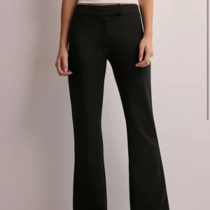 Svarta kostymbyxor - Snygga svarta kostymbyxor från nelly med låg midja och bootcut-stil, väldigt skönt tyg💕Köpte dom här på Plick, men säljer då dom tyvärr var för stora på mig! Inga tecken på användning!! Storlek 36/S💕 Hör av er för fler bilder