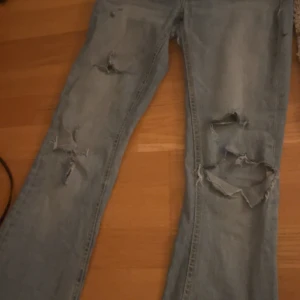 Ljusa slitna jeans - Säljer ett par ljusa jeans med slitningar på knäna och låren. De har en straight passform och är perfekta för en avslappnad look. Jeansen är i bra skick trots slitningarna som ger dem en cool stil. Perfekta för vardagsbruk! (De har hål mellan benen men de är lagade och de syns inte när man har på sig de)
