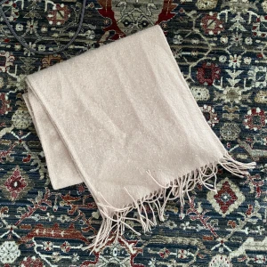 Rosa halsduk med fransar - Säljer en superfin rosa halsduk med fransar i kanterna. Den är perfekt för att hålla sig varm under kyliga dagar. Materialet känns mjukt och skönt mot huden. Passar perfekt till både höst och vinteroutfits. Ett måste för garderoben! 🍂🧣 Ganska nopprig och en fläck, som säkert går bort i tvätten! 