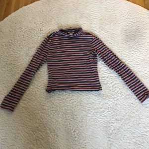 Regnbågsrandig tajt, långärmad tröja. Xs-Monki - Säljer en tajt långärmad, regnbågsrandig tröja, tunn. 