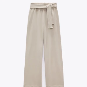 Zara byxor - Helt oanvända (med lappen kvar) byxor den zara i bomull. Fkn knytdetalj i midjan och är ganska raka i benen.  Stretchiga och väldigt skönt material