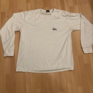 Stussy Longsleeve Vit - Riksfett Stussy Longsleeve Strl L, denna kan omöjligt vara använd mer än 10ggr (Jag köpte den ds) och är i riktigt fint skick, riktigt steal price helt ärligt men vill rensa grejer o köpa en asfett Margiela Knit på Grailed 😝😅, frågor kom DM, knvitto✅