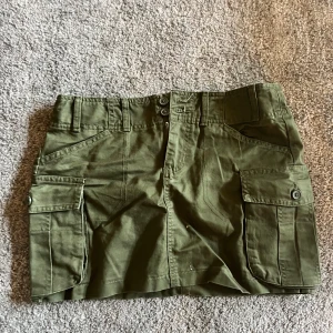 Brandy Melville Cargo Skirt - Jag säljer den här militär kjolen från brandy melville. Jag köpte den för 1-2 år sedan och den är inte riktigt min stil längre. Den sitter jätte snyggt på o är knappt använd. Skriv om ni har några andra frågor eller om ni är intresserade🤗
