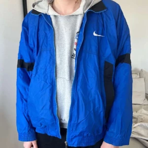 Vintage Nike Windbreaker - Supersnygg och vintage vindjacka. Använt skick, men någon liten skavank (se bild 3).  Men syns knappt och påverkar inte funktionen.