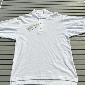 Vintage ny colombia piké - Helt ny deadstock colombia piké från 90talet aldrig använd aldrig tvättat. Har lite smutsfläckar men allt går bort i tvätten. Har en boxy fit och är oversized eftersom den är från 90talet.  52cm axelbredd 52cm midja 73cm lång bak och 69cm där fram