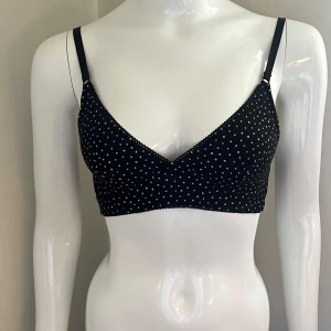 Svart prickig mjuk bh Monki - Endast använd en gång. Söt svart bh med vita prickar från Monki. Stängs med hyskor där bak. Storlek S (75 A/B) 