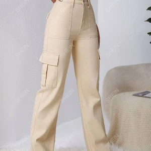 Beige cargopants från SHEIN - Säljer ett par snygga beige cargopants från SHEIN. De är högmidjade och har en straight passform. Byxorna har praktiska fickor på sidorna och är perfekta för en avslappnad stil. Materialet ser ut att vara bomull, vilket gör dem bekväma att bära.