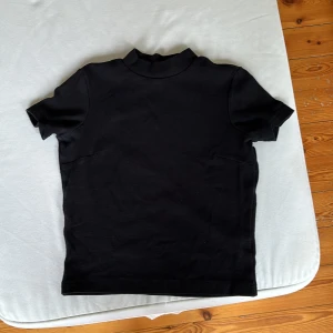 Två t-shirts - En grå och en svart t-shirt båda från Monki i storlek xs men jag skulle säga att xxs också är ganska passande. Båda en liten krage
