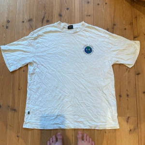 Vit t-shirt från Sweet SKTBS - Säljer en vit t-shirt från Sweet SKTBS i storlek S men sitter som en stor M. Den har ett coolt tryck med en glad jordglob och texten 'Take Care of Each Other'. Perfekt för vardagsbruk och för att sprida lite positivitet!