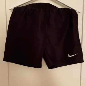 Svarta Nike badbyxor  - Nike badbyxor i storlek 158-170. Fantastiskt bra skick då de knappt är använda. Skriv till mig för ytterligare frågor.