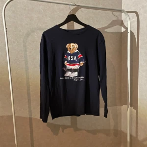 Ralph lauren long sleeve - Säljer denna feta ”bear long sleeve” tröja från Ralph Lauren. Tröjan har inga defekter och är sparsamt använd. Priset är inte hugget i sten. Tröjan är lite stor på mig som är omkring 178cm så den bör passa någon som är mellan 182 och 185 beroende på hur man vill att den ska sitta. Har ni fler frågor är det bara att skriva 🙌