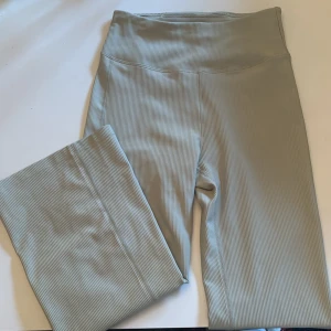 Grå ribbade bootcut leggings från Röhnisch - Snygga grå ribbade leggings från Röhnisch med hög midja. Perfekta för träning eller en avslappnad dag. Tillverkade i ett mjukt och stretchigt material för bästa komfort.