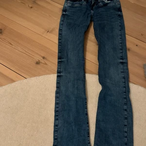 Blå bootcut jeans - Snygga blå bootcut jeans med klassisk femficksdesign. Perfekta för en avslappnad stil.