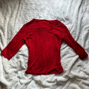 Röd topp med trekvartsärm - Snygg röd topp med trekvartsärm, perfekt för en färgklick i garderoben. Enkel design som passar till många olika outfits. Uppskattad S/M, köptes second hand och saknar etikett🤗