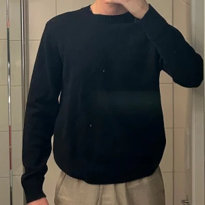 Samsøe samsøe stickad tröja - Säljer en klassisk svart stickad tröja med rund hals och långa ärmar. Perfekt för kyligare dagar och enkel att matcha med olika outfits.