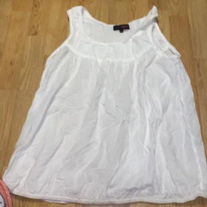 Vit ärmlös topp från Zoul - Säljer en vit ärmlös topp från Zoul. Toppen har en rund halsringning och är tillverkad i ett lätt och luftigt material, perfekt för varma dagar. Faller jättefint över bröstet.