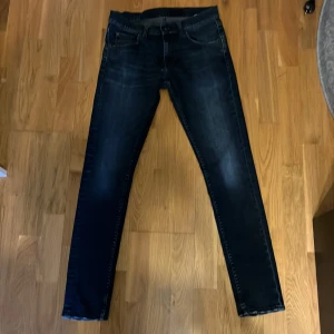 Tiger Of Sweden Jeans  - Snygga mörkblå jeansbyxor med en slim passform. De har klassisk femficksdesign och stängs med dragkedja och knapp. Modell: Evolve Perfekta för en stilren look. Tveka ej på att fråga. 