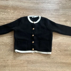 Svart kofta med vita detaljer, skönt material, guldiga knappar❤️ - Mysig svart kofta med vita kanter och knappar framtill. Två praktiska fickor på framsidan. Perfekt för kyliga dagar. Skriv till mig innan ni köper så jag vet❤️
