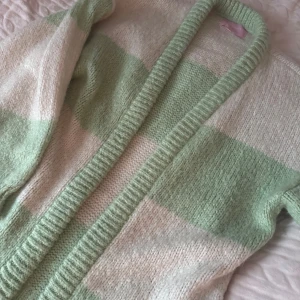 Randig stickad kofta från Bianca - Mysig stickad kofta från Bianca i grönt och vitt. Den har ett randigt mönster och långa ärmar, perfekt för kyliga dagar. Koftan är i storlek XXS och har en skön passform. Är bara använd fåtal gånger💕köpte den för ca 800, säljes för 500💕Men kan diskutera pris!!