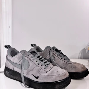 Grå Nike Air Force sneakers - Snygga grå Nike Air Force sneakers i mocka med svarta detaljer och snörning. Perfekta för en stilren look.