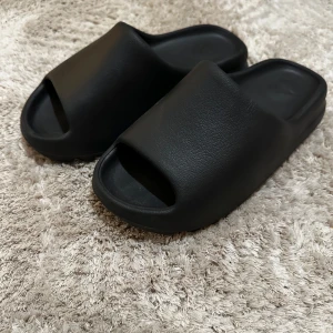 Adidas YEZZY slides - Tjena! Säljer dessa as feta Adidas YEZZY slides i en nice colour way❗️| Skick 10/10! De har aldrig blivit använda! 🙅| Storlek: UK 8,5/EU 43 men de passar också bra på UK 8/ EU 42 👍❗️| Ny pris ca 2000 kr 💵| Färg: Svart 🖤| Tillbehör: Den har tyvärr inga tillbehör med 🙁| Fraktar: Spårbart genom PostNord och Instabox 📦| Det är bara att höra av sig för mer information 😆| Allt gott 👊❗️