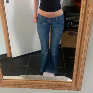 Blå jeans från Levi's - Snygga blå Levi's jeans med bootcut-stil. Klassisk femficksdesign och låg midja. Perfekta för en avslappnad look.