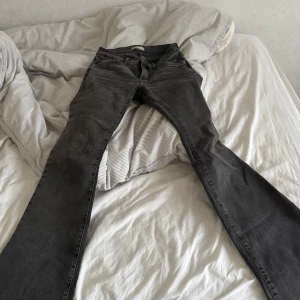Grå bootcut jeans med låg midja  - Snygga grå jeans från Perfect Jeans i damstorlek S. De har en klassisk design med dragkedja och knapp framtill. Perfekta för en avslappnad stil.
